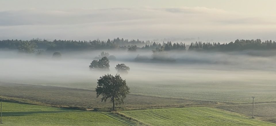 Das schöne Chiemgau im Nebel und sanften Hügeln im Hintergrund.
